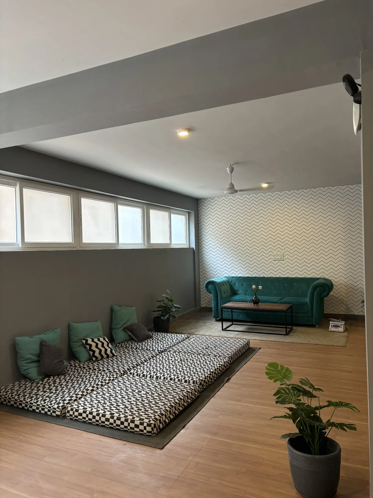 Lounge with floor mattresses, cushions and a teal sofa