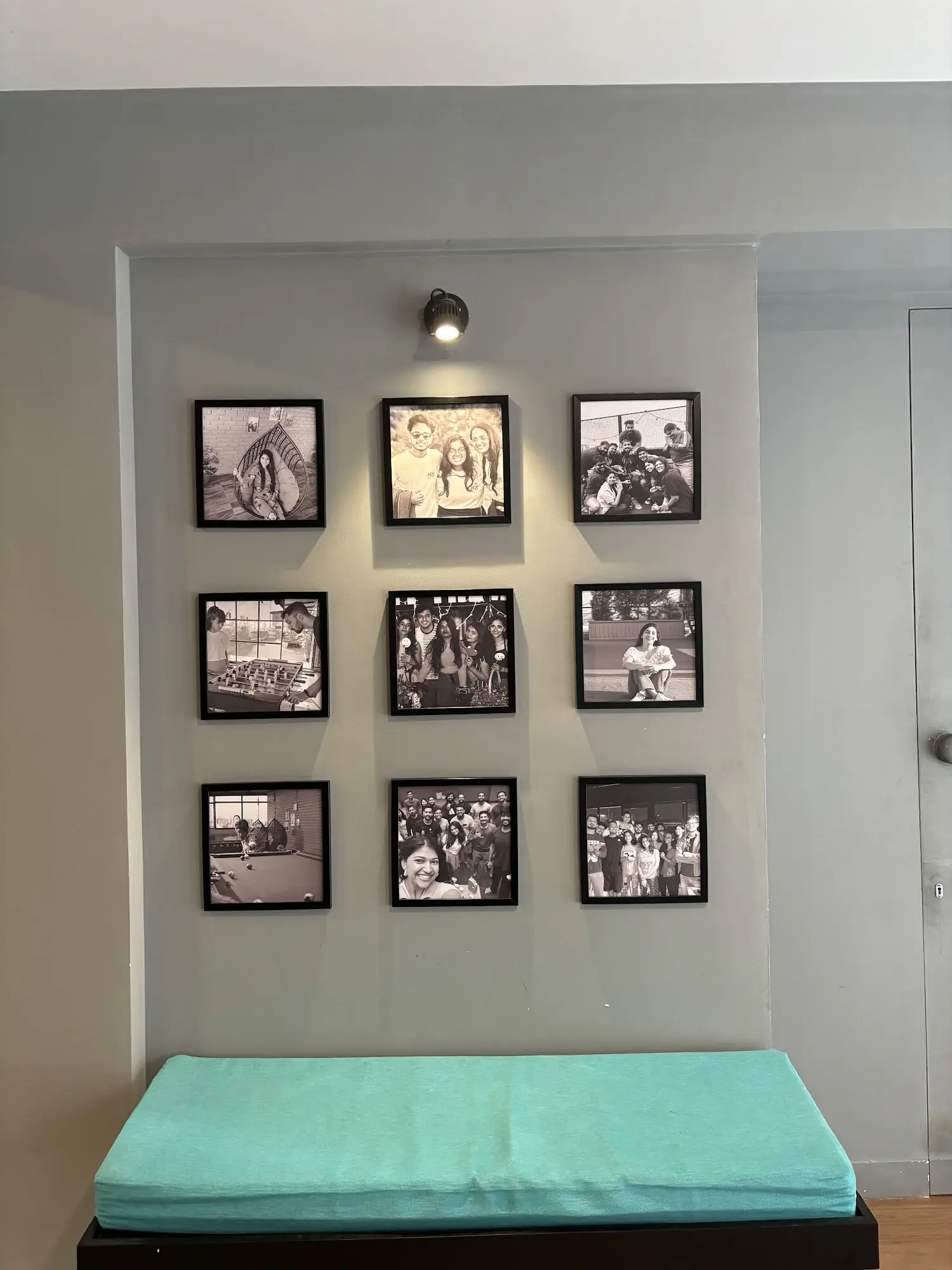 Wall of framed resident photos above a teal bench