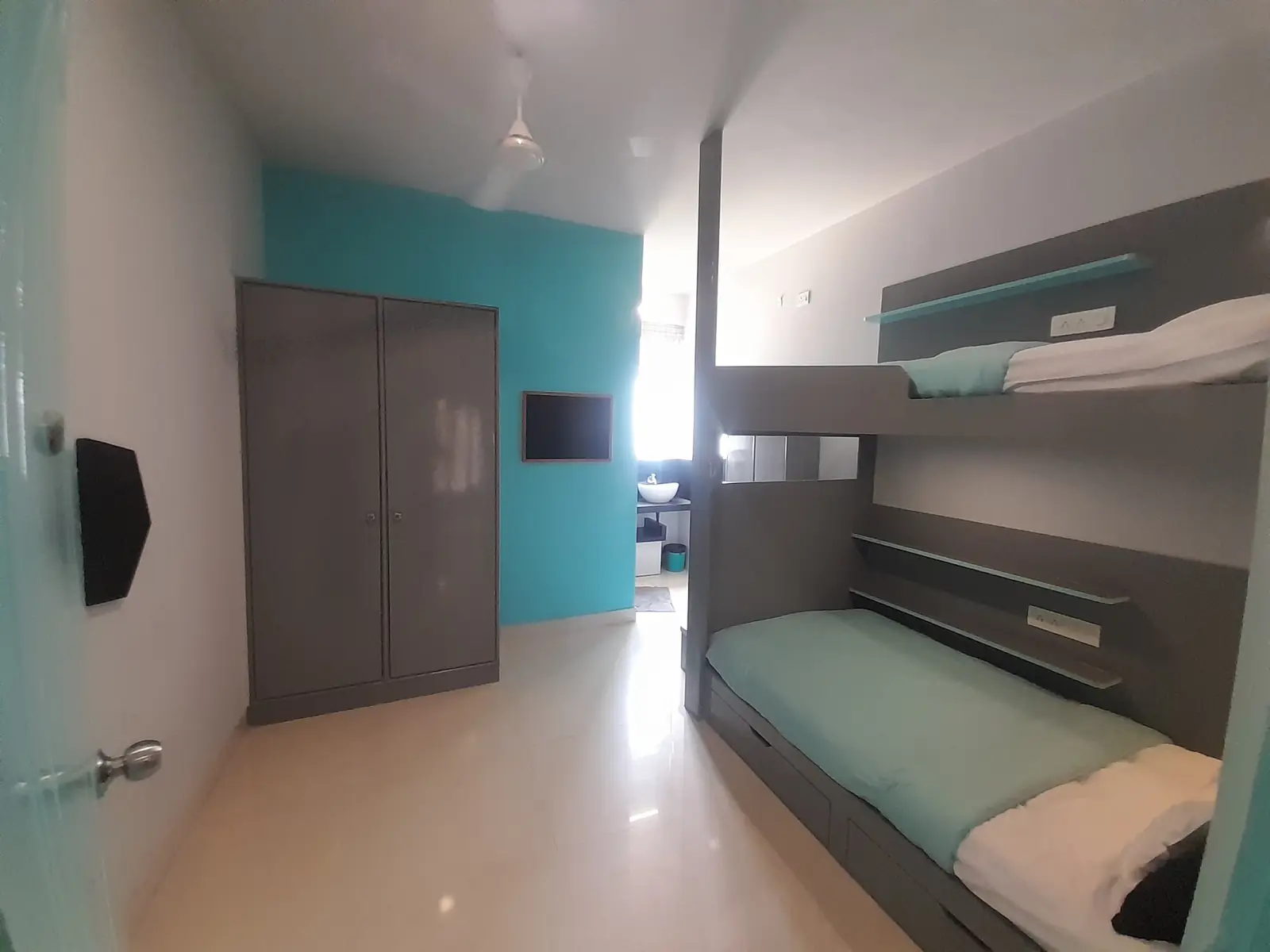 Room with bunk beds and a teal wall