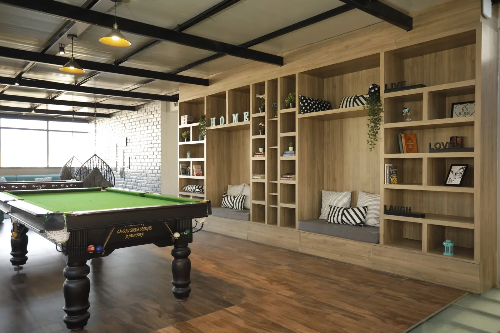 Pool table beside a wall of bookshelves
