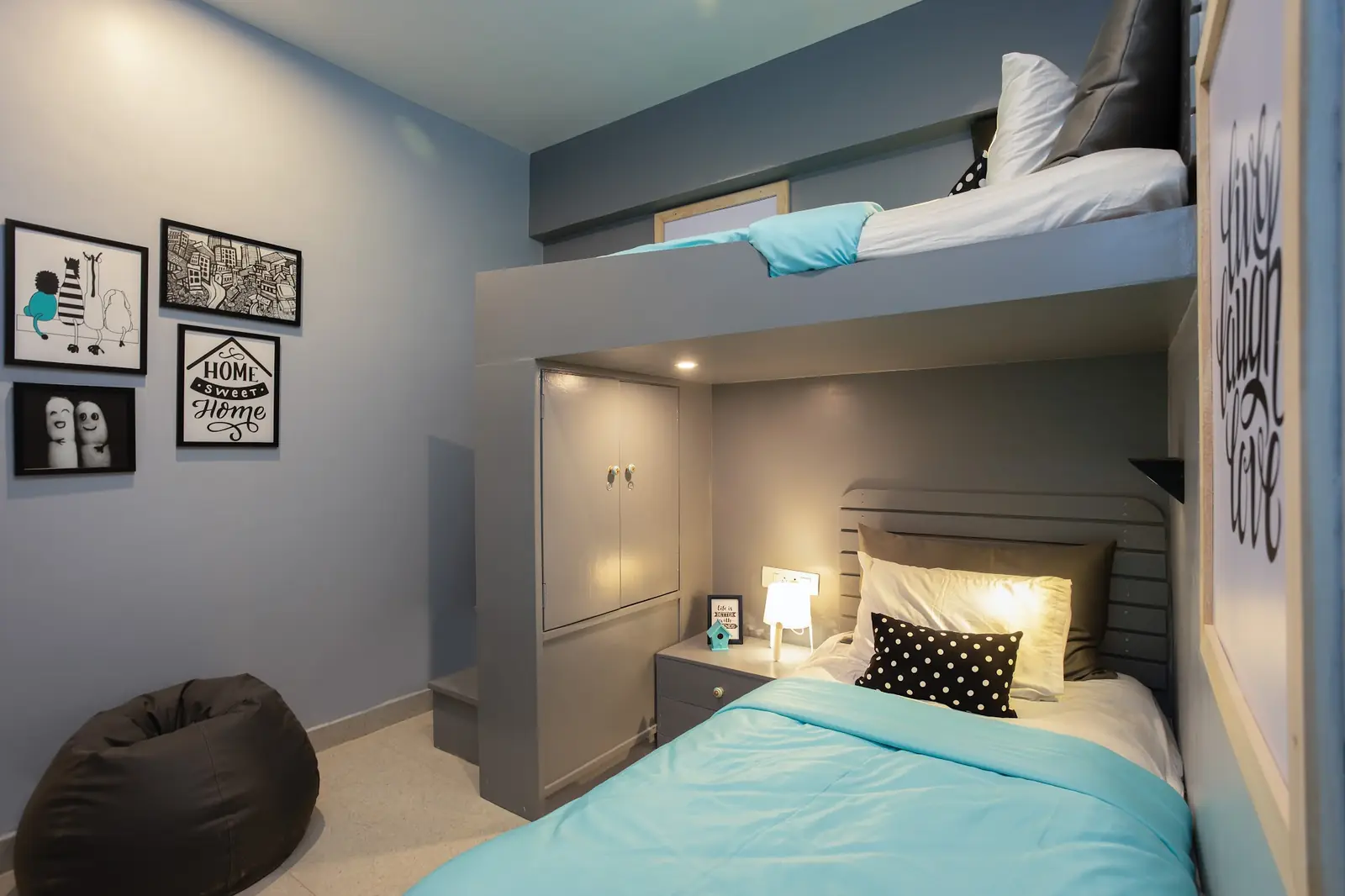 Room with a loft bed above a single bed