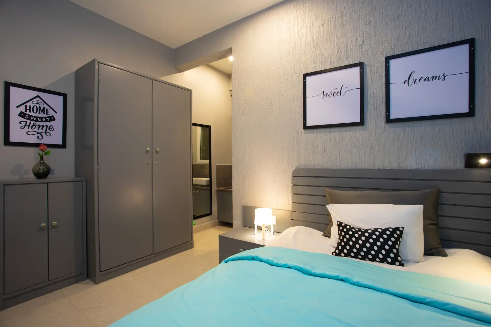 Private room with a bed, wardrobe and framed prints