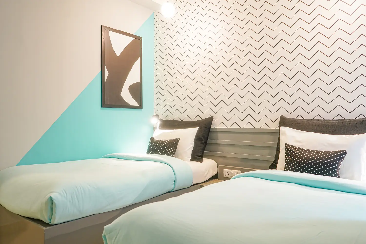 Studio deluxe with twin beds and a teal wall