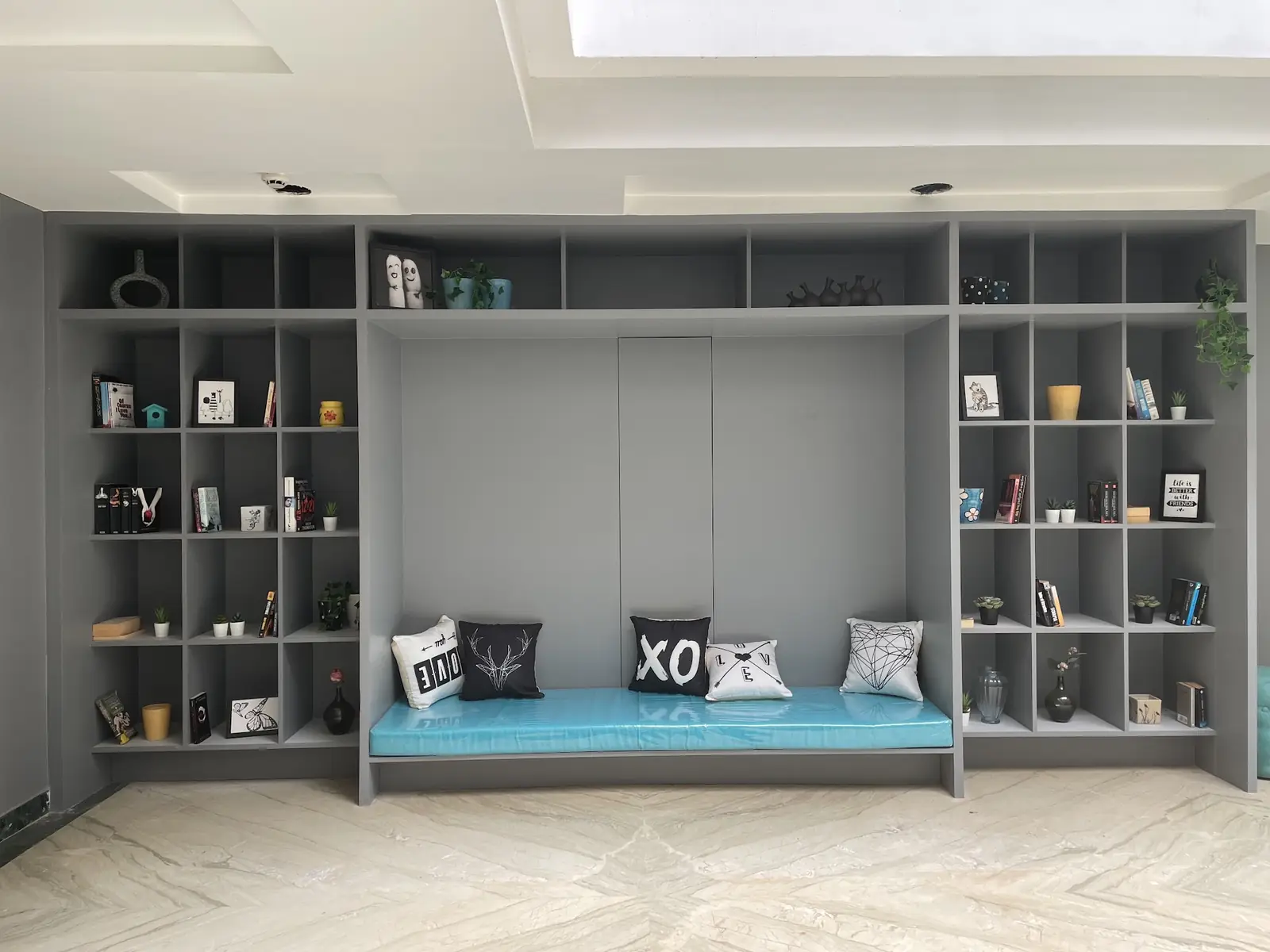 Bookshelves around a teal window seat