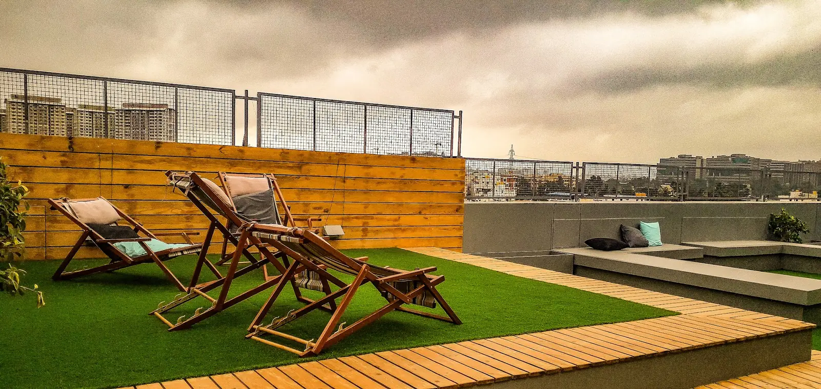 Deck chairs on a rooftop lawn at sunset