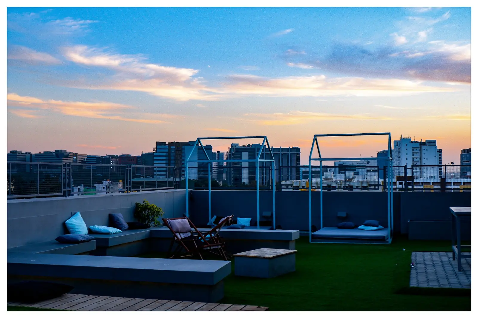 Rooftop lounge at dusk with the city skyline behind it