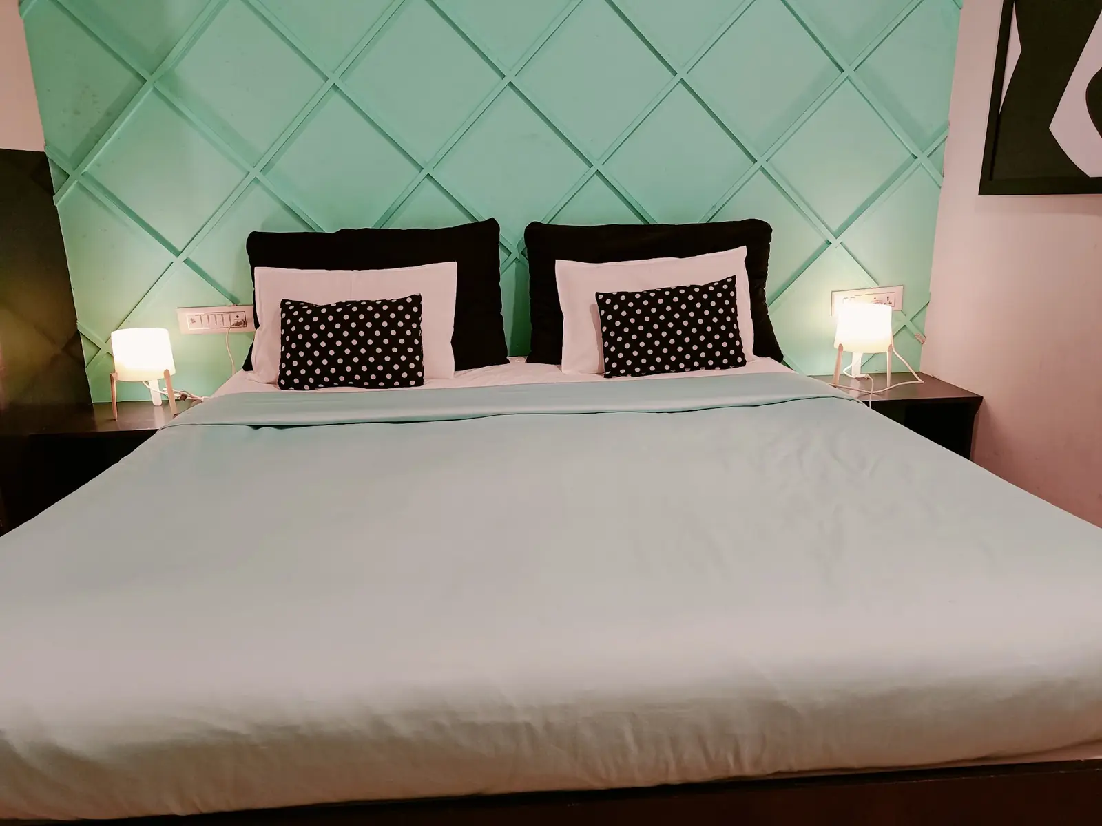 Room with a king size bed and a padded teal headboard
