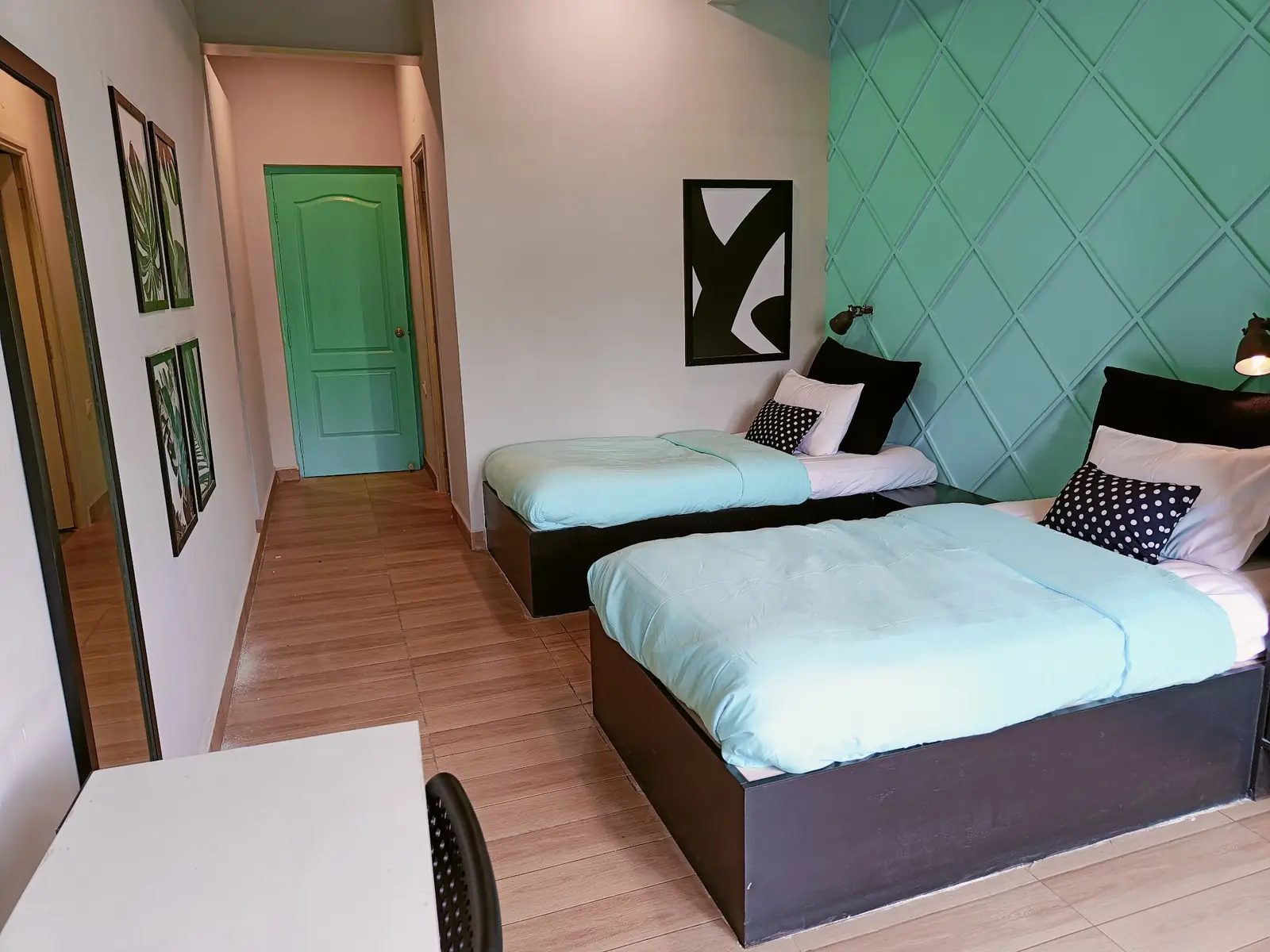 Twin room with two beds and a teal wall