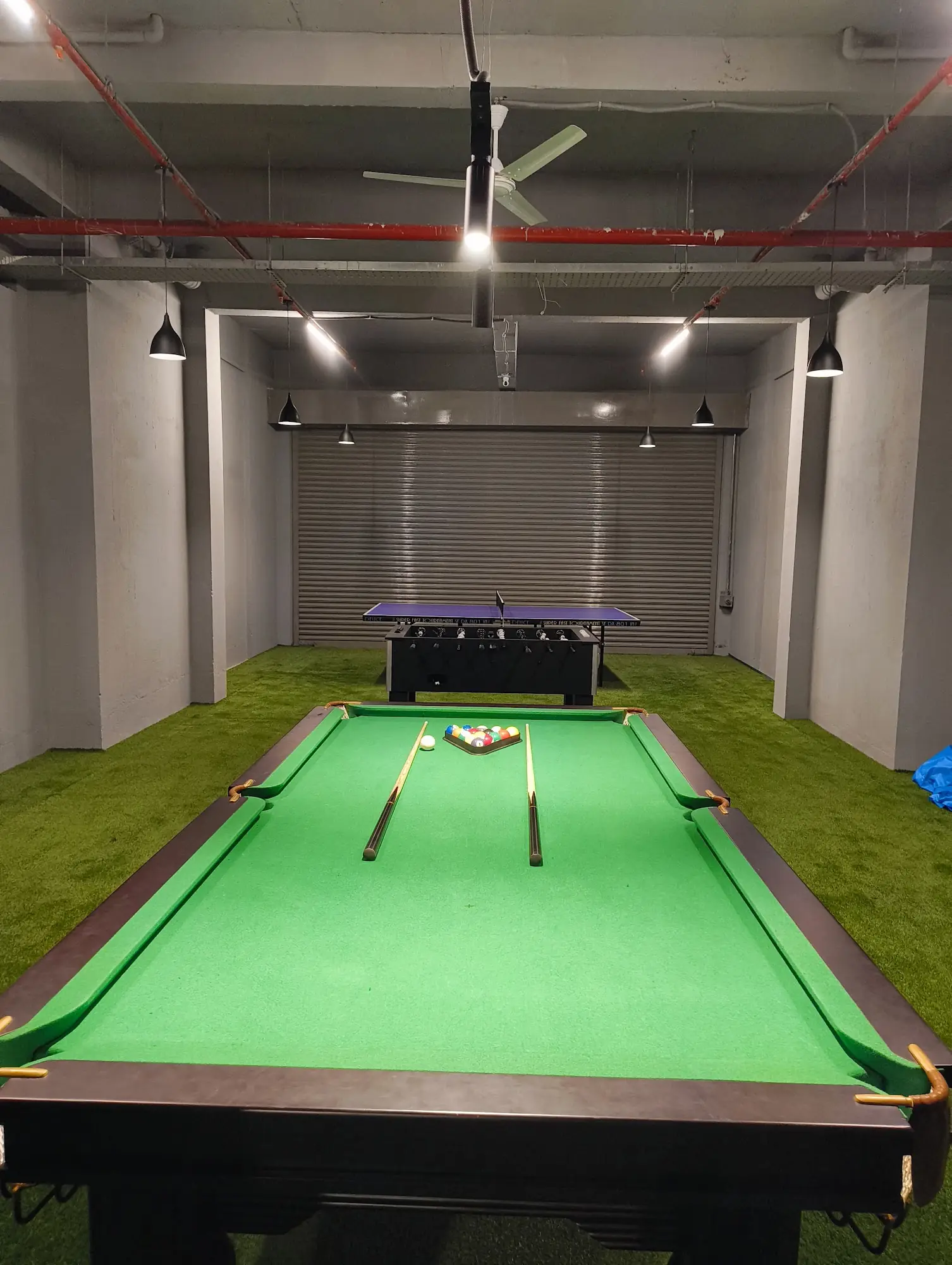 Game room with a pool table on green turf